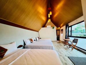 a bedroom with two beds and a large window at Tropical Valley Homestay - Villas in Phong Nha