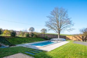 een achtertuin met een zwembad in het gras bij Le Petit Goulet Superbe Gite Campagne in Saint-Aubin-des-Ormeaux