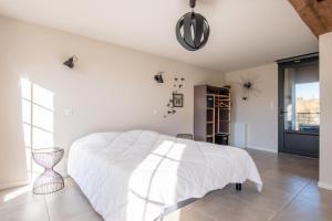 een slaapkamer met een wit bed en een groot raam bij Le Petit Goulet Superbe Gite Campagne in Saint-Aubin-des-Ormeaux