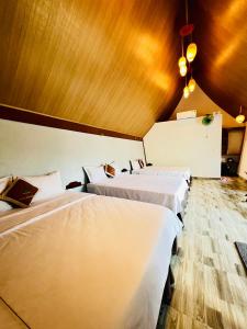 a group of three beds in a room at Tropical Valley Homestay in Phong Nha