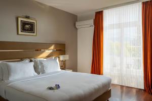 a bedroom with a large white bed and a window at Country Inn Anant Ayodhya in Ayodhya