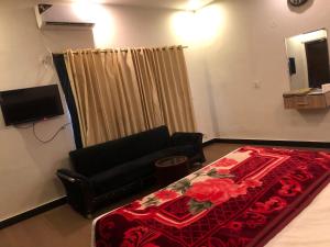 Defence-Mark-Hotel في لاهور: غرفة معيشة مع سرير وأريكة