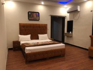 Defence-Mark-Hotel في لاهور: غرفة نوم بسرير كبير وتلفزيون