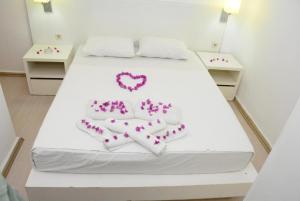 a white bed with a heart shaped cake on it at Bodrum Park Hotel in Gümbet
