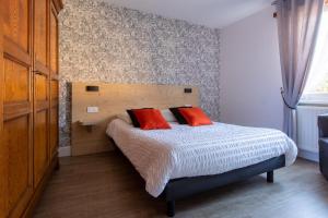 um quarto com uma cama com duas almofadas vermelhas em Gite Haydi em Itterswiller