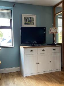 a television on a white cabinet in a room at Seaview House Reenard South in Cahersiveen