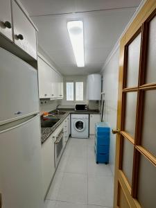 - une cuisine avec des placards blancs et un lave-linge/sèche-linge dans l'établissement Apartamento Alcocebre Rentalholidays ref 067, à Alcossebre