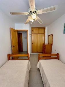 1 dormitorio con 2 camas y ventilador de techo en Apartamento Alcocebre Rentalholidays ref 067, en Alcossebre