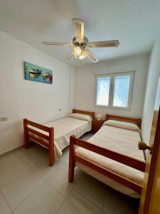 - une chambre avec 2 lits et un ventilateur de plafond dans l'établissement Apartamento Alcocebre Rentalholidays ref 067, à Alcossebre
