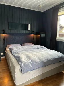 a bedroom with a large bed with blue walls at Leilighet Ski in/out, golf in Vradal