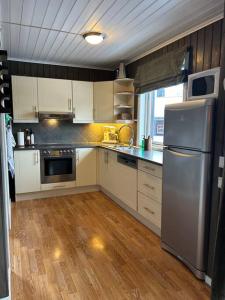 a kitchen with white cabinets and a stainless steel refrigerator at Leilighet Ski in/out, golf in Vradal