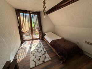 a small bedroom with a bed and a window at Villa Mona Zeleni Vir in Olovo