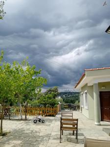 un patio con 2 bancos y un cielo nublado en Giola aparments and studios 2, en Astris
