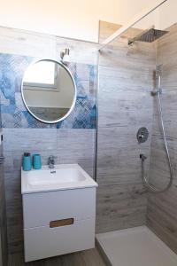 uma casa de banho com um lavatório e um espelho em Appartamento Sorso em Sorso