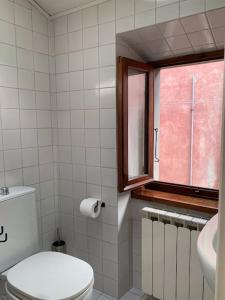 een badkamer met een toilet en een raam bij La Casa di Mezzo - The Middle House in Monte Marcello