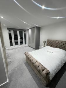 Events Venue في Wealdstone: غرفة نوم بسرير كبير في غرفة بها نوافذ