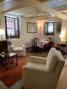 een woonkamer met witte meubels en een tafel en stoelen bij La Casa di Mezzo - The Middle House in Monte Marcello