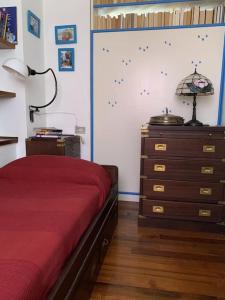 een slaapkamer met een rood bed en een dressoir bij La Casa di Mezzo - The Middle House in Monte Marcello