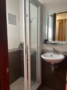 a bathroom with a glass shower and a sink at DINH DINH 2 AIRPORT HOTEL in Ho Chi Minh City