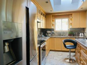 een keuken met een zwarte koelkast en een stoel. bij Riverwood Home in Mississauga