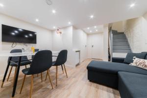 ein Wohnzimmer mit einem Sofa, einem Tisch und Stühlen in der Unterkunft Appartement Sous-Plex 4 Personnes Neuilly Maillot in Neuilly-sur-Seine