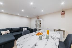un soggiorno con tavolo in marmo e divano di Appartement Sous-Plex 4 Personnes Neuilly Maillot a Neuilly-sur-Seine