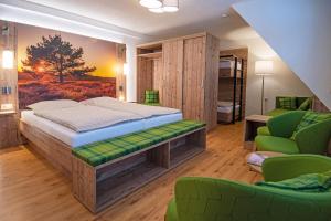 1 dormitorio con cama, sofá y sillas en Glockenhof Studtmann en Amelinghausen