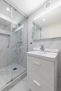 bagno bianco con doccia e lavandino di Appartement Sous-Plex 4 Personnes Neuilly Maillot a Neuilly-sur-Seine