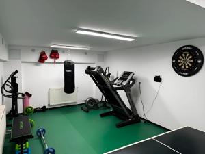 Zimmer mit Fitnessraum mit Laufband und Uhr in der Unterkunft Evie's Tree House in Dragomirna
