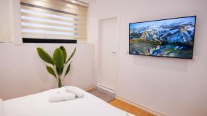 a white room with a tv on the wall at 313 Villa Boutique Hotel City Center in Tirana