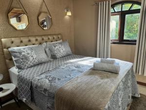 um quarto com uma cama e um espelho na parede em Chalé 08 com hidro no coração de Penedo em Itatiaia