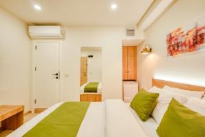 ein Schlafzimmer mit einem weißen Bett und grünen Kissen in der Unterkunft Elephant In The Room Hotel in Istanbul
