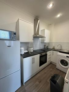 a kitchen with white cabinets and a stove top oven at Apartments 7 Greenfield Road in Liverpool