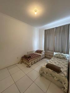 a room with two beds on a tiled floor at Apto em ótima localização! in Lages