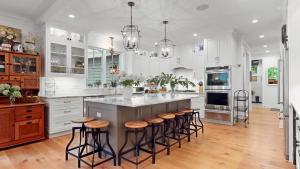 a kitchen with white cabinets and a island with bar stools at Fern Creek in South Haven