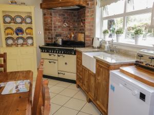 Il comprend une cuisine équipée d'une cuisinière et d'un comptoir. dans l'établissement Gortin Cottage, à Ballymena