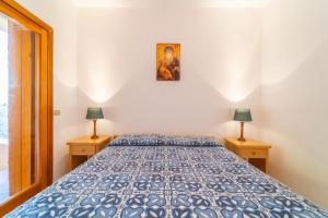 una camera con un letto blu con due lampade di Punzy by DomusAway a Porto Istana