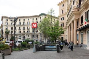 un grande edificio con un cartello M in mezzo a una strada di Certosa Suite a Napoli