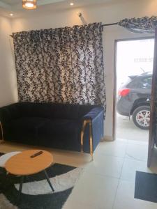 sala de estar con sofá negro y mesa en Kondjikpé, en Cotonou