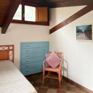 1 dormitorio con cama, silla y vestidor en All'Ombra del Palmeto, en Taranto