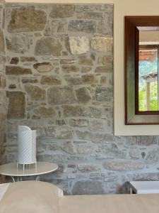 pared de piedra en una habitación con espejo en Agriturismo Piano di Andrea, en Ostigliano