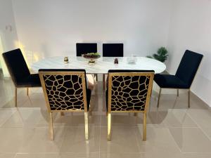 a dining room table with four chairs and a white table at F22R4 Small room attach bath at beach in Ajman 