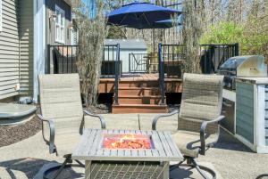 un patio con due sedie, un tavolo e un ombrellone di Fireside Retreat a South Haven