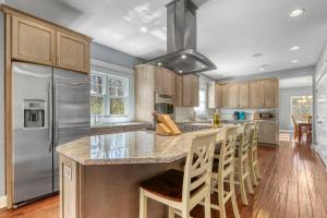 una cucina con una grande isola con sgabelli da bar di Fireside Retreat a South Haven