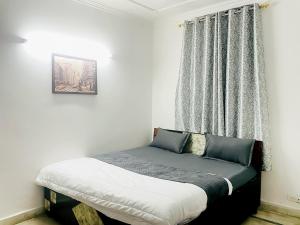 a small bed in a room with a window at Hotel Aura Opposite Max Hospital in New Delhi