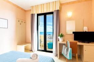 a bedroom with a window with a view of the ocean at Hotel Metropole in Rimini