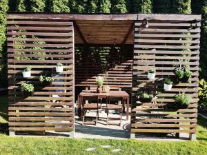 einem Holzzaun mit einem Tisch und Topfpflanzen in der Unterkunft Lawendowo- sauna jacuzzi domki w ogrodzie i apartamenty w kamienicy in Sandomierz