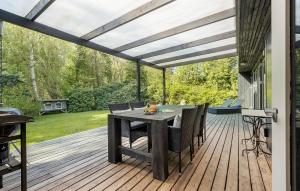 a patio with a table and chairs on a deck at 3 Bedroom Awesome Home In Vejby in Vejby
