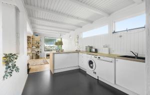 a white kitchen with a washer and dryer at 3 Bedroom Awesome Home In Vejby in Vejby
