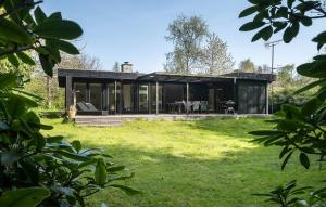 a black house with a grassy yard at 3 Bedroom Awesome Home In Vejby in Vejby